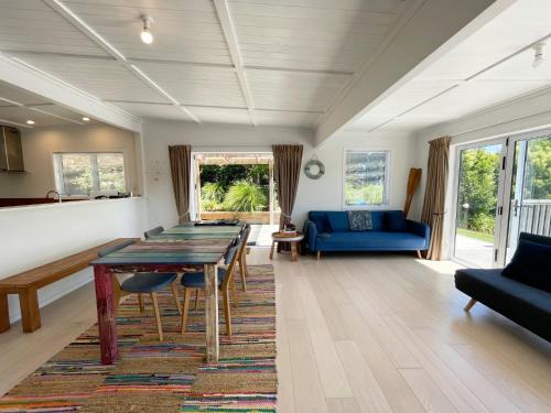 a living room with a table and a blue couch at Oneroa Village Oasis - Waiheke Escapes in Blackpool