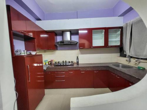- une cuisine avec des placards rouges et un évier dans l'établissement Cozy Heaven (1-Room)BW, à Guwahati