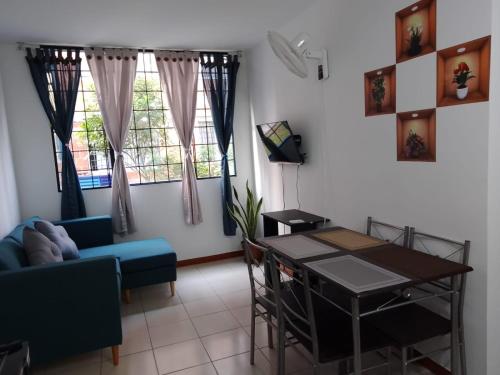 salon ze stołem i niebieską kanapą w obiekcie Apartamento en Villavicencio w mieście Villavicencio