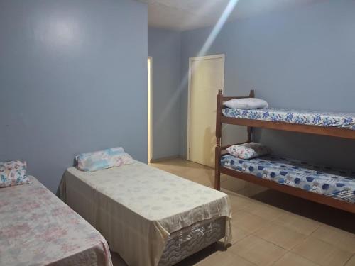 a room with two beds and a bunk bed at Hostel CAMI in Erechim