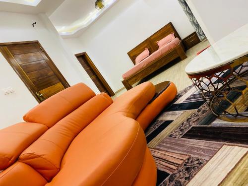 an orange leather couch in a living room at Résidence El Hadji Annexe in Dakar