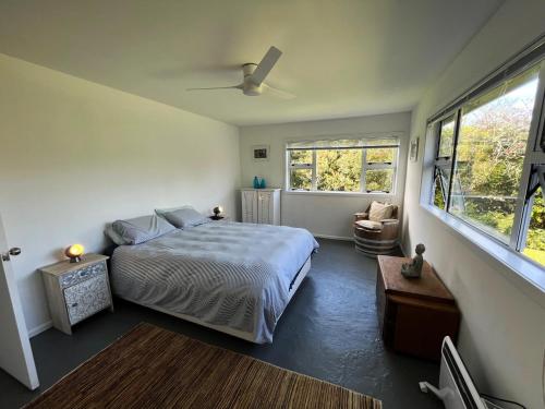 a bedroom with a bed and a ceiling fan at Oneroa Village Oasis - Waiheke Escapes in Blackpool