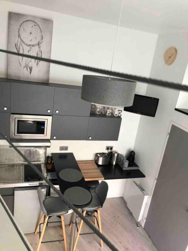 une cuisine avec une table et des chaises dans une cuisine dans l'établissement Studio moderne à Clermont-Ferrand – 35 m² + Parking gratuit, à Clermont-Ferrand