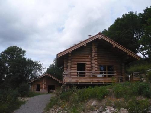 une cabane en rondins sur le côté d'une colline dans l'établissement Chalet bois chaleureux avec terrasse, internet et animaux acceptés - FR-1-496-187, à Saint-Martin-la-Sauveté