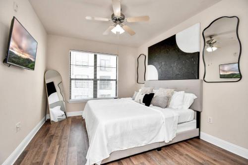 a bedroom with a white bed and two mirrors at 1BR APT Near NRG Uptown Galleria Med Center in Houston