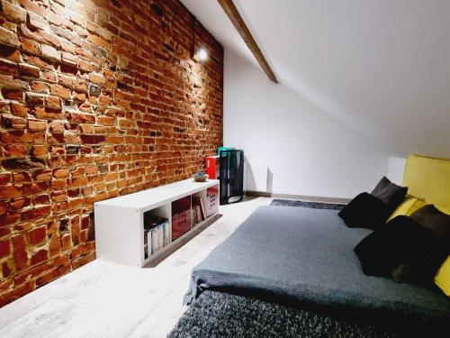 Un dormitorio con una pared de ladrillo y una cama en Gîte Steenwerck, 3 pièces, 4 personnes - FR-1-510-172, en Steenwerck