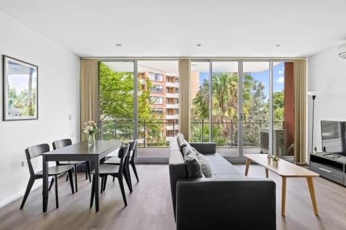 a living room with a couch and a table at 2BR Apt in Strathfield Sleeps 6 in Sydney