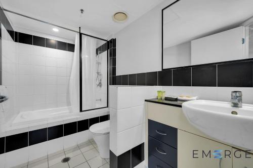 a bathroom with a sink and a tub and a toilet at Ipanema Holiday Resort in Gold Coast