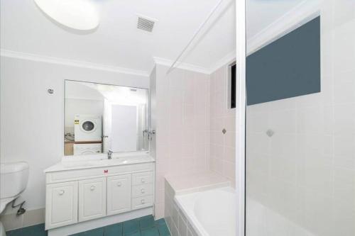 湯斯維爾的住宿－Football fever on the ocean front!，白色的浴室设有浴缸和水槽。