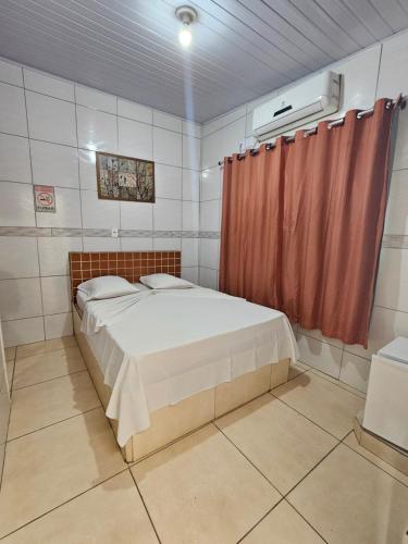 a bedroom with a bed and a red curtain at Arahra Hotel in Aparecida de Goiania