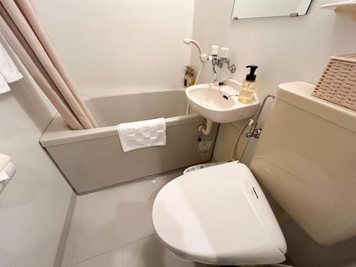 a small bathroom with a toilet and a sink at Pension Sunset Beach in Nakijin