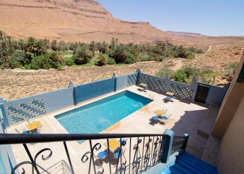 a balcony with a swimming pool in the desert at Palma Ziz in Aït Athmane