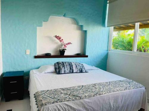 Schlafzimmer mit einem Bett mit blauer Wand in der Unterkunft Amplio departamento con Jacuzzi privado. in Ixtapa