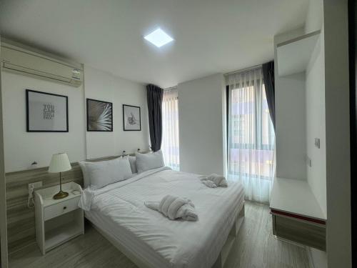 a white bedroom with a large bed and a window at @ style sukhumwit bangna3 in Bangna