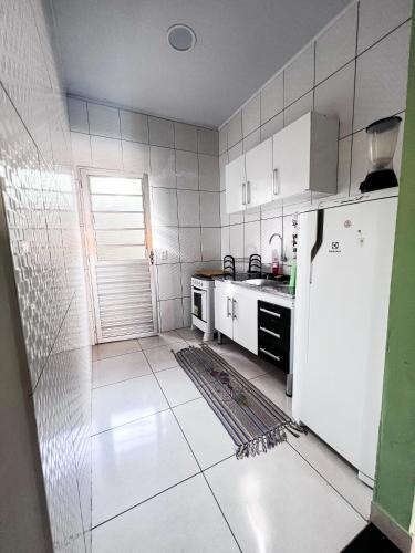 Chalé Aconchego dos Milagres في ساو ميغيل دوس ميلاجريس: مطبخ مع ادوات بيضاء وثلاجة