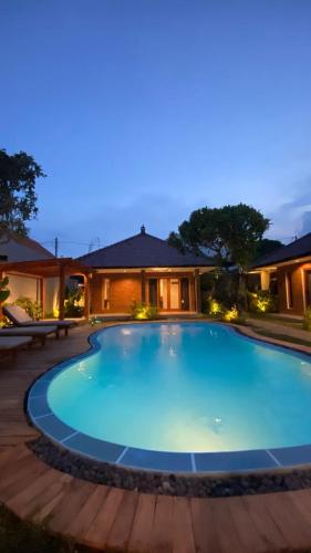 a large blue swimming pool in front of a house at O.B oemah bone homestay in Sanur