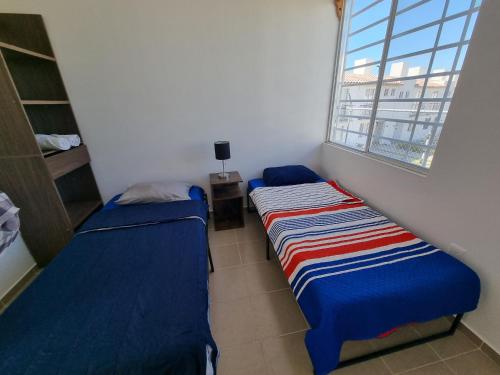 Duas camas num pequeno quarto com uma janela em Casa amplia Garde SD em Querétaro