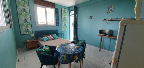 una camera da letto con un letto, un tavolo e delle sedie di Ti' cocon des îles a Le Moule