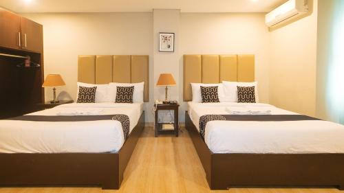 Asrodel Hotel RedPartner في مدينة دافاو: غرفه فندقيه سريرين في غرفه