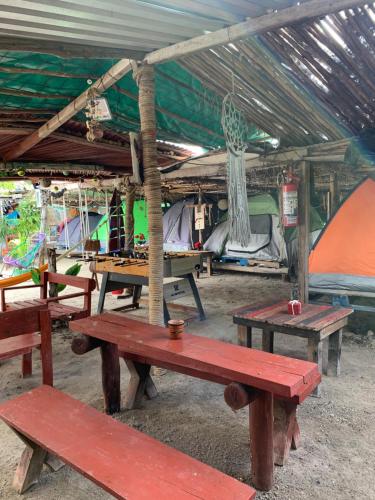 un grupo de mesas de picnic en una tienda en Casa de los Santos Camping y eco cabañas en Holbox Island
