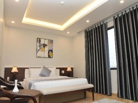 - une chambre avec un grand lit et une fenêtre dans l'établissement An Tín Hotel, à Hai Phong