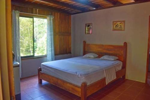 ein Schlafzimmer mit einem Bett in einem Zimmer mit einem Fenster in der Unterkunft Capitan Morgan Homes & Tours in Pital