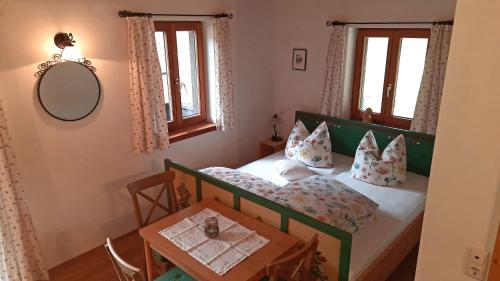 a small bedroom with a bed and a table at Bauernhof Auerhof Ferienwohnung in Aschau im Chiemgau