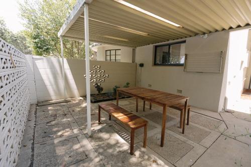 a patio with a wooden table and a bench at Apartments on Morrow in Wagga Wagga