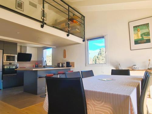 une salle à manger et une cuisine avec une table et des chaises dans l'établissement Appartement T3 avec Mezzanine et Terrasse au Cœur de Collioure, Proche Plages et Commerces - FR-1-309-431, à Collioure
