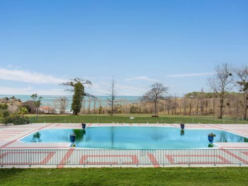 une grande piscine dans un parc avec une clôture dans l'établissement Grand appartement familial avec piscine près de Saint-Jean-de-Luz - FR-1-2-439, à Urrugne