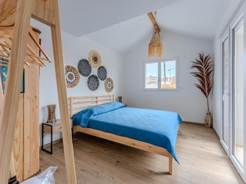 une chambre avec un lit avec une couverture bleue dans l'établissement Appartement Neuf T3 Climatisé, Centre Station, Proche Océan, Terrasse Privative, Parking Sécurisé - FR-1-521-240, à Biscarrosse