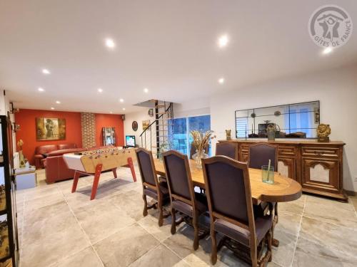 une salle à manger et un salon avec une table et des chaises dans l'établissement Charmante maison mitoyenne avec jardin, proche forêt, animaux admis, parking & WiFi - FR-1-510-203, à Hasnon