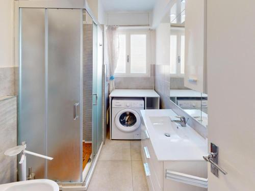 une salle de bain avec une machine à laver et un lavabo dans l'établissement Spacieux 2P climatisé centre-ville Menton avec grande terrasse, proche plages et commerces - FR-1-196-351, à Menton