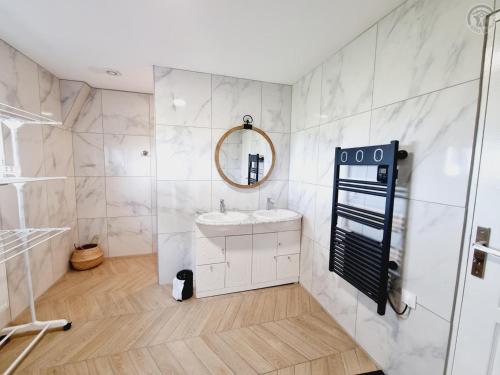 ein weißes Badezimmer mit einem Waschbecken und einem Spiegel in der Unterkunft Gîte Sains-du-Nord, 6 pièces, 11 personnes - FR-1-510-204 in Sains-du-Nord