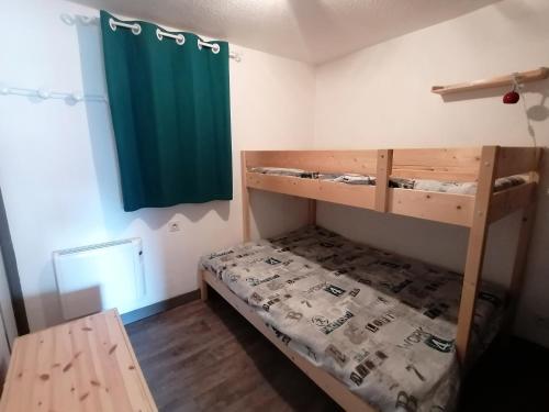 a bedroom with two bunk beds and a green curtain at Appartement Saint-François-Longchamp, 3 pièces, 6 personnes - FR-1-635-136 in Saint-François-Longchamp