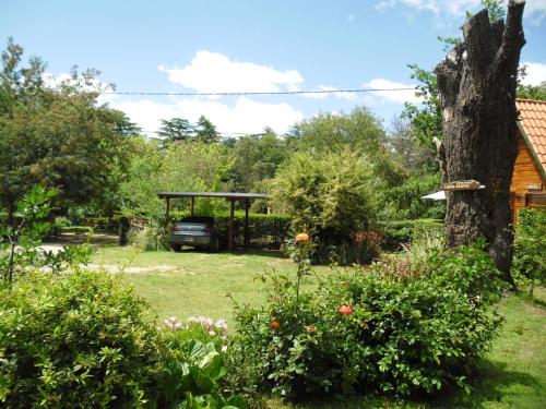 a garden with a gazebo and a tree at Cabañas Ñuke Mapu in Villa Ventana
