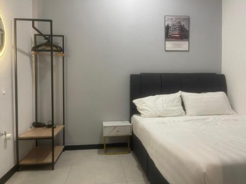 Private Room Bukit Bintang في كوالالمبور: سرير مع اللوح الأمامي الأسود في غرفة النوم