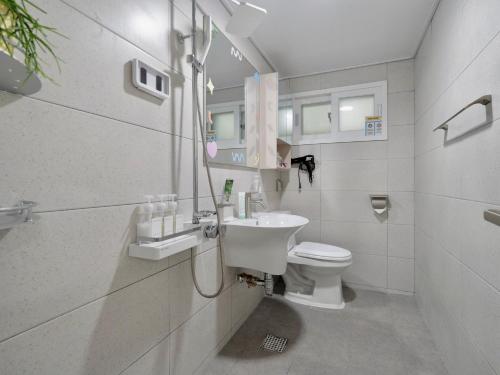 a white bathroom with a sink and a toilet at Hygge - Urban Hideout with four comfort beds in Seoul