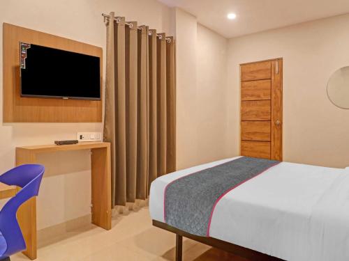 Schlafzimmer mit einem Bett, einem TV und einem Schreibtisch in der Unterkunft Townhouse 1202 White Ridge KPHB OPP JNTU in Kukatpally
