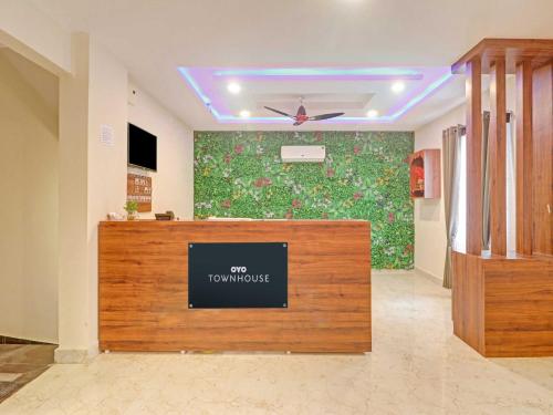 a room with a reception desk and a wall with flowers at Townhouse White Ridge KPHB OPP JNTU in Hyderabad