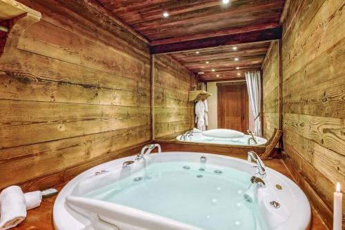 a bathroom with a large tub and a mirror at SOMPTUEUX CHALET BARON MEGEVE VUE.Jaccuzi.4 mn a pied au centre in Megève