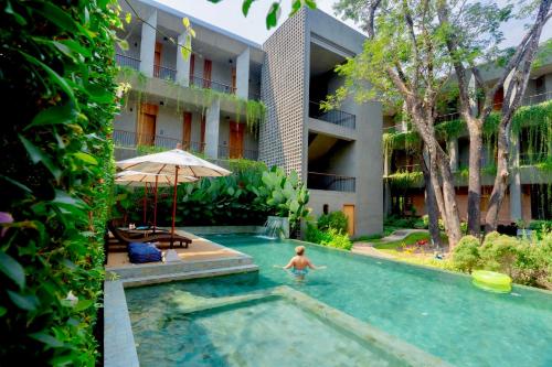 a boy in a swimming pool next to a building at Proud Phu Fah Muang Chiang Mai in Chiang Mai
