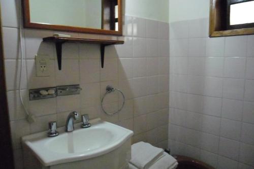 y baño con lavabo, aseo y espejo. en Cabañas Ñuke Mapu en Villa Ventana