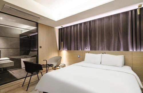 a hotel room with a bed and a desk at H Hotel Wangsimni in Seoul