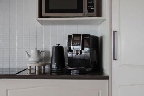 a kitchen counter with a coffee maker and a microwave at View Point: Ocean Views & Near CBD in Burnie