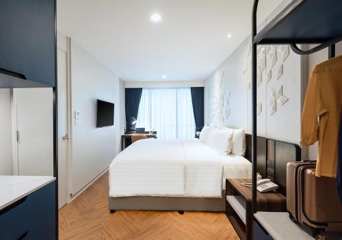 a bedroom with a white bed and a window at Amanta Hotel & Residence Sathorn in Bangkok