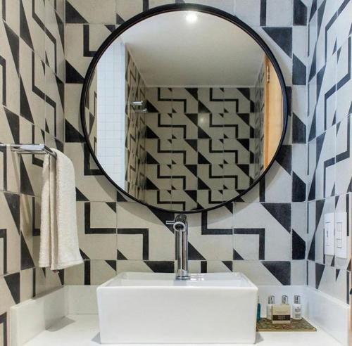 La salle de bains est pourvue d'un miroir et d'un lavabo blanc. dans l'établissement Casa Decu, à Mexico
