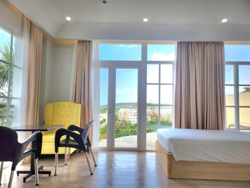 1 dormitorio con 1 cama, mesa y sillas en Hi Beach House Phu Quoc - Sunset Town en Phu Quoc