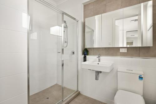 La salle de bains est pourvue d'une douche, d'un lavabo et de toilettes. dans l'établissement Clare St Apartments by Urban Rest, à Port Adelaide