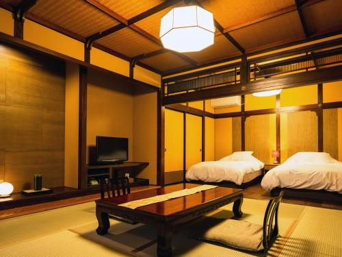 新発田市にある東栄館のベッド2台、テーブル、テレビが備わる客室です。
